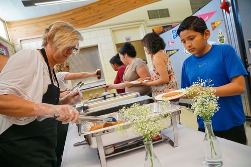 teacher serving food to students